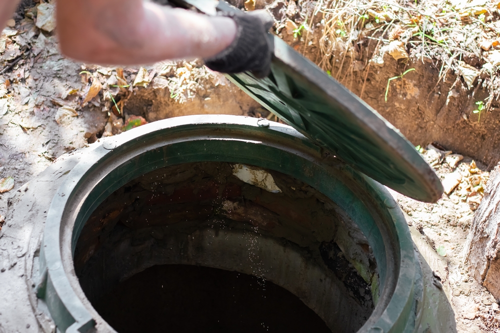 The,man,opens,a,sewer,hatch.,septic,tank,inspection,and